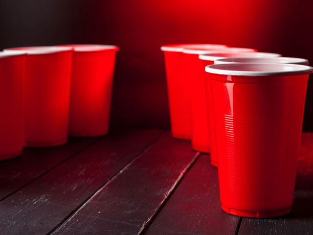 Setting red solo cups up in a circle to play the Chandelier Drinking Game