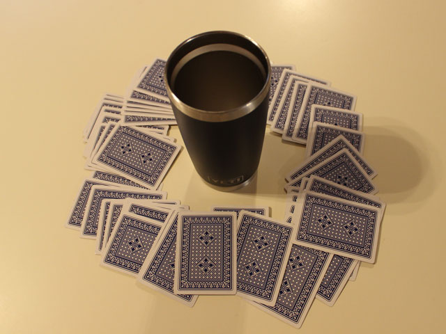 A game of Ring of Fire with the cards spread out around the central cup