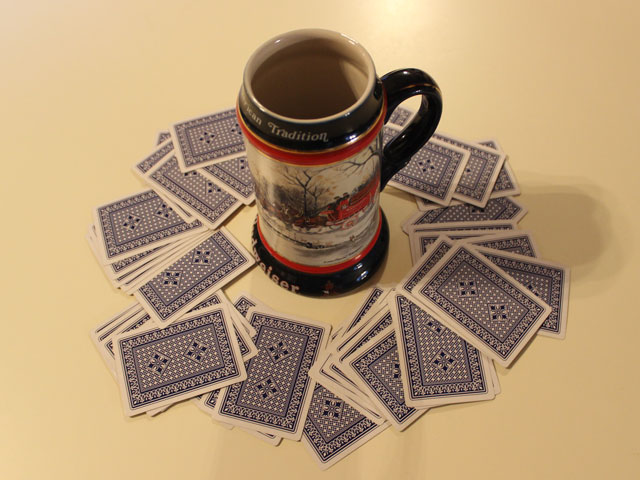 A game of King's Cup with the cards spread around a Beer Stein