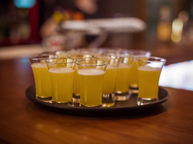 A handful of shot glasses filled with beer to play the Power Hour drinking game with