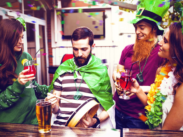 Four friends playing a drinking game on Saint Patrick's Day at the bar