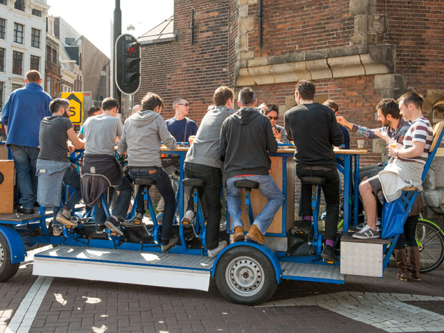 Several people on a Pedal Bike doing a Pub Crawl