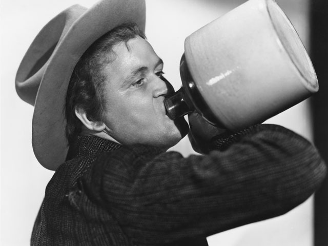 A man chugging beer out of a jug for the Anything But a Cup party